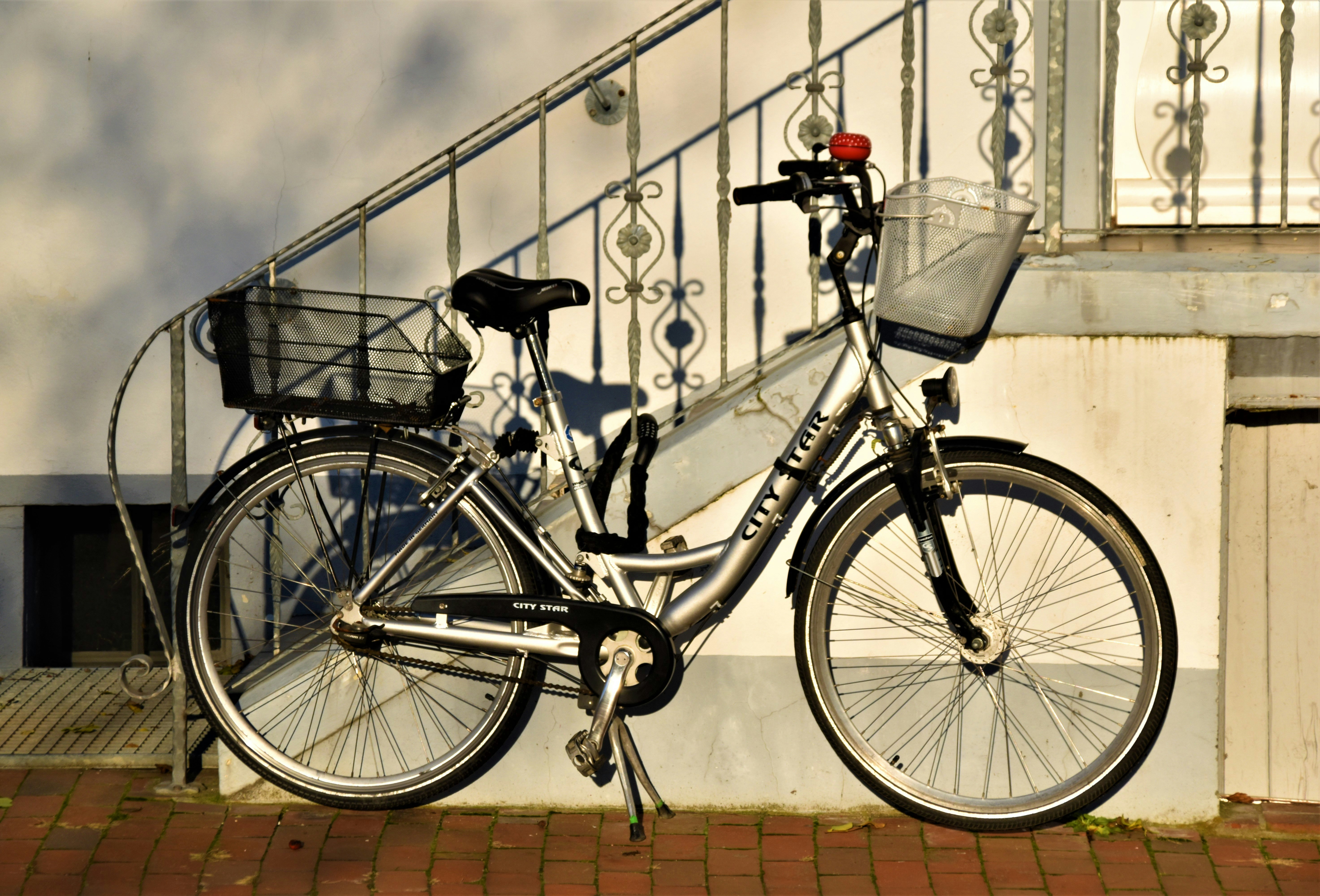 black and gray mountain bike leaning on gray metal fence